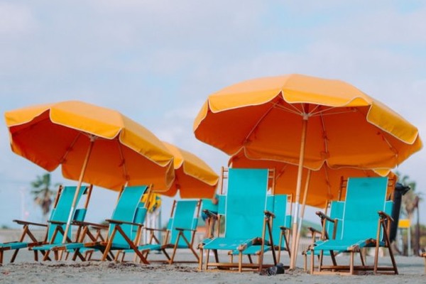 closeup photo of lounger chairs and beach umbrellas